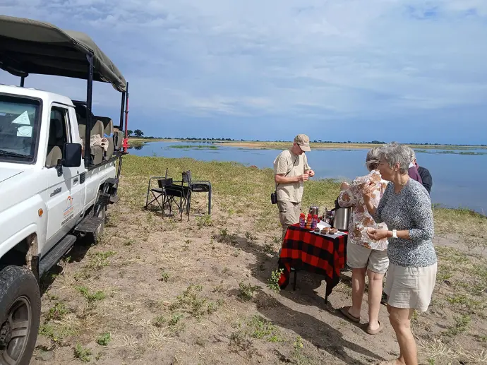 Traveller having lunch by the Chobe river Traveller having snack during a day tri[